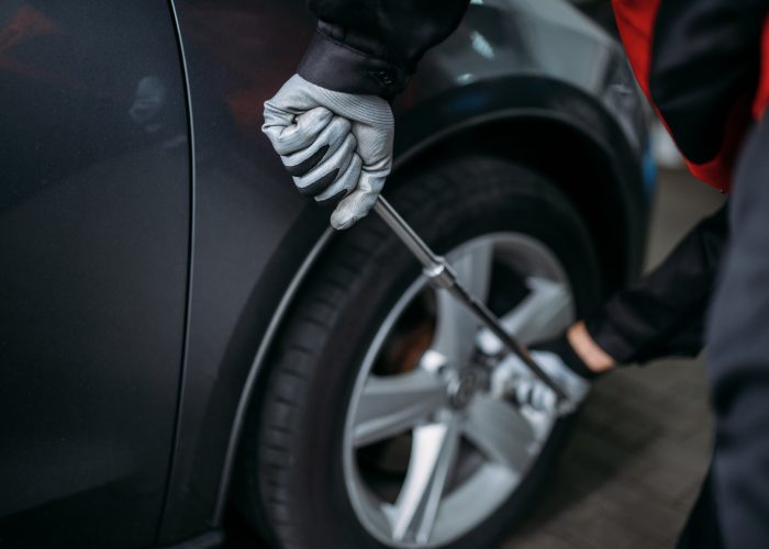 Mechanic unscrews the wheel in tire service